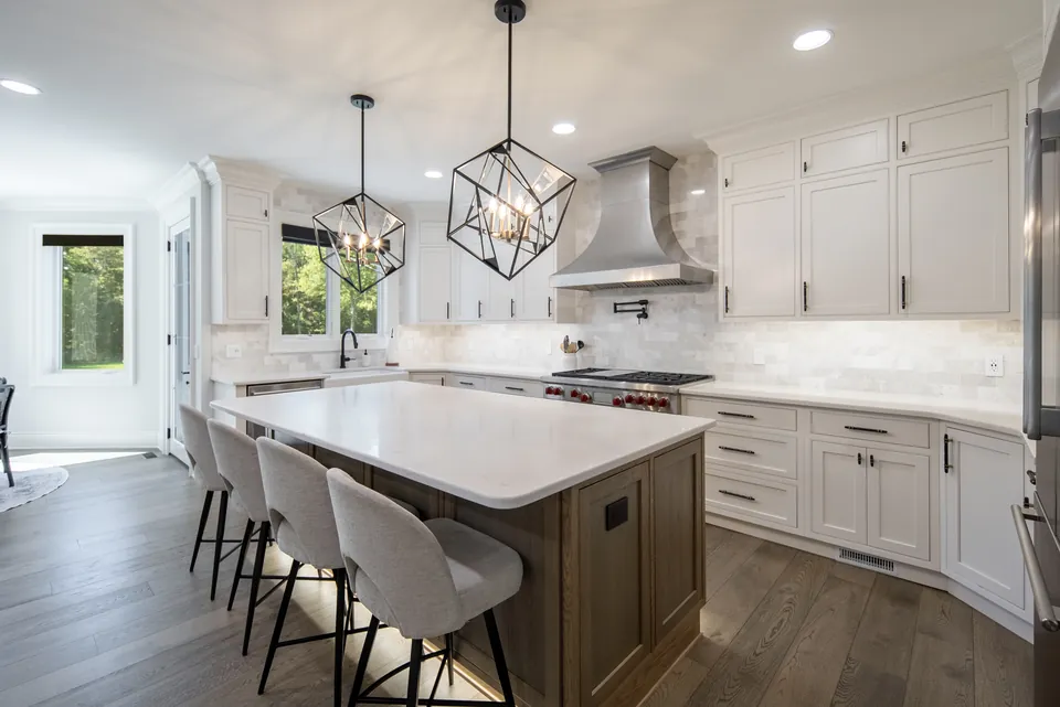 Kitchen island with seating for four under two geometric pendant lights
