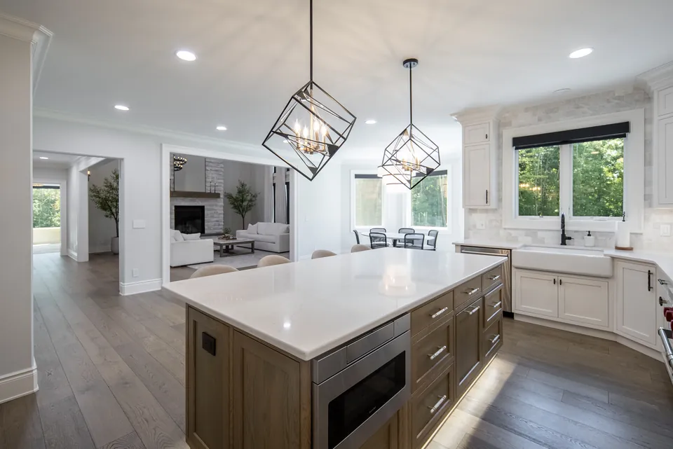 Kitchen island with a wood-tone base and built-in microwave drawer beside the cooking wall