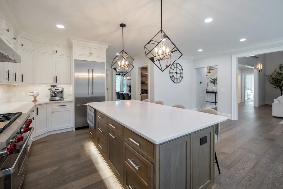LED toe-kick lighting under a wood island base with a white quartz top